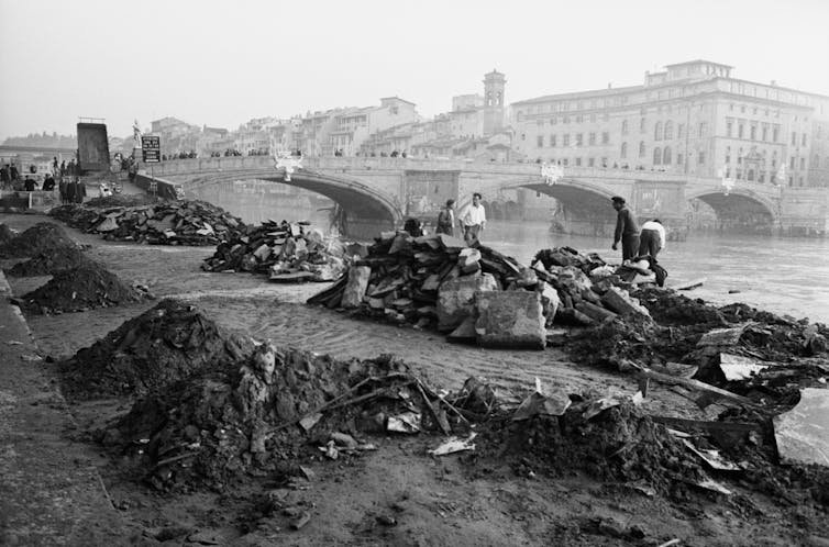 Debris is heaped on the banks of a river.